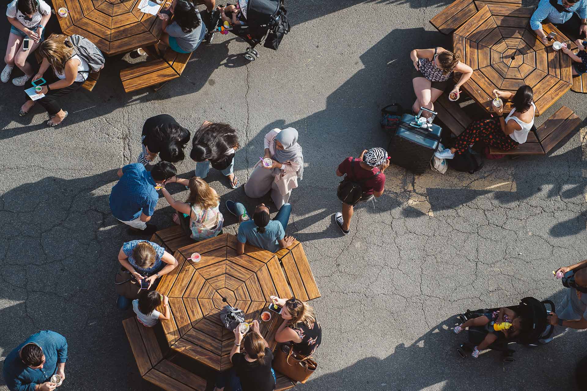 view from above of people dining outside at three round tables