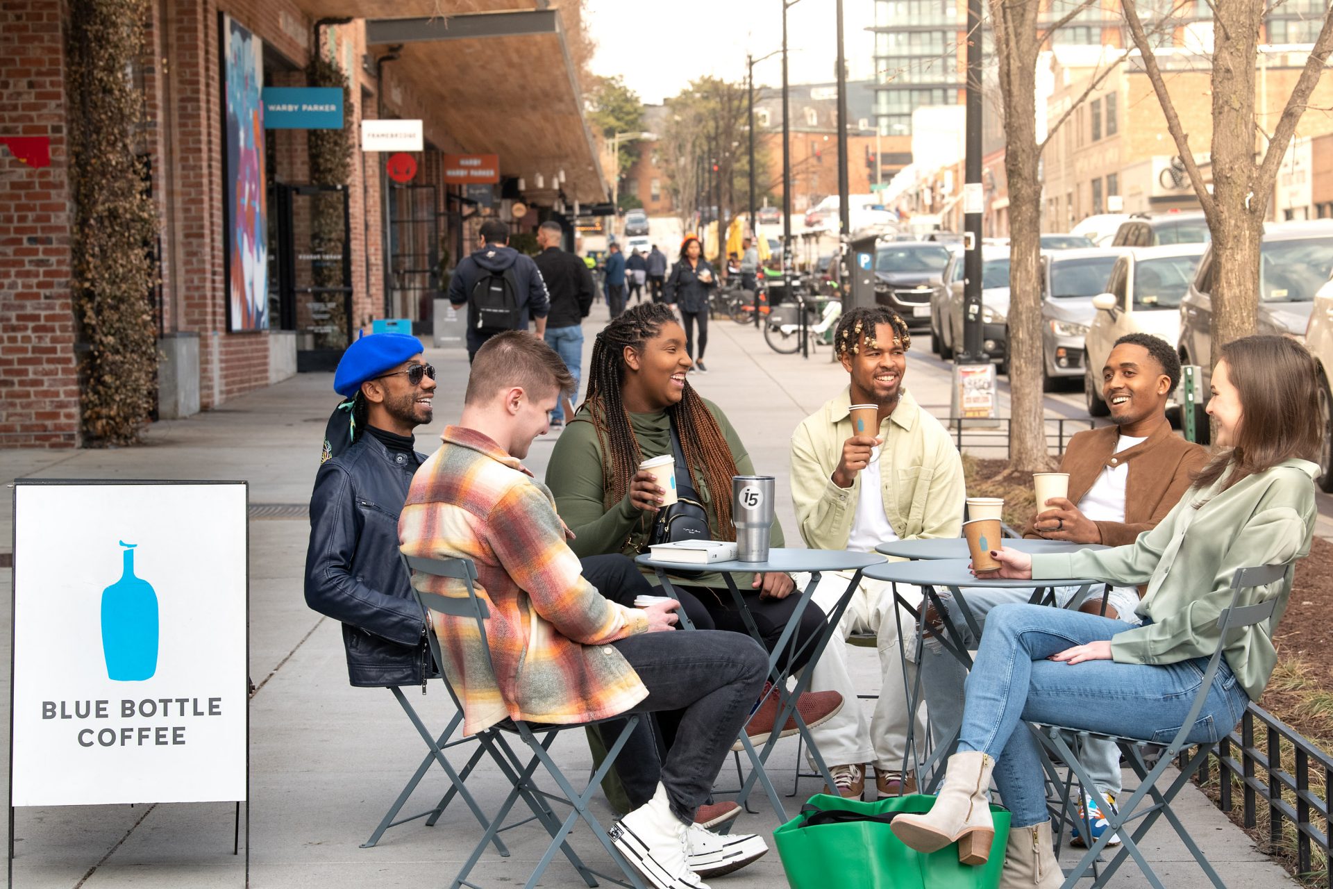 view from above of people dining outside at three round tables